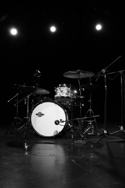 a black and white photo of a drum set, an album cover, by Jeremy Henderson, flickr, purism, empty stage, color corrected, jack white, little