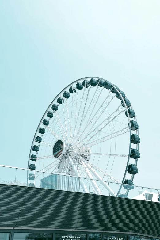 a large ferris wheel sitting on top of a building, by Niko Henrichon, on the ocean, in hong kong, clear sky, 2022 photograph