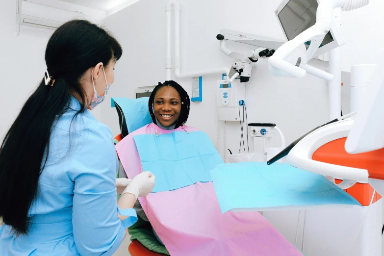 a woman sitting in a chair in a dentist's chair, by Elaine Hamilton, pexels contest winner, hurufiyya, sterile colours, ( ( dark skin ) ), sky blue, lachlan bailey