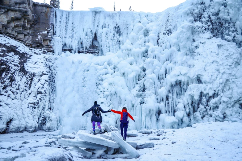 two people standing in front of a frozen waterfall, by Terese Nielsen, pexels contest winner, banff national park, 🦩🪐🐞👩🏻🦳, walking on ice, various posed
