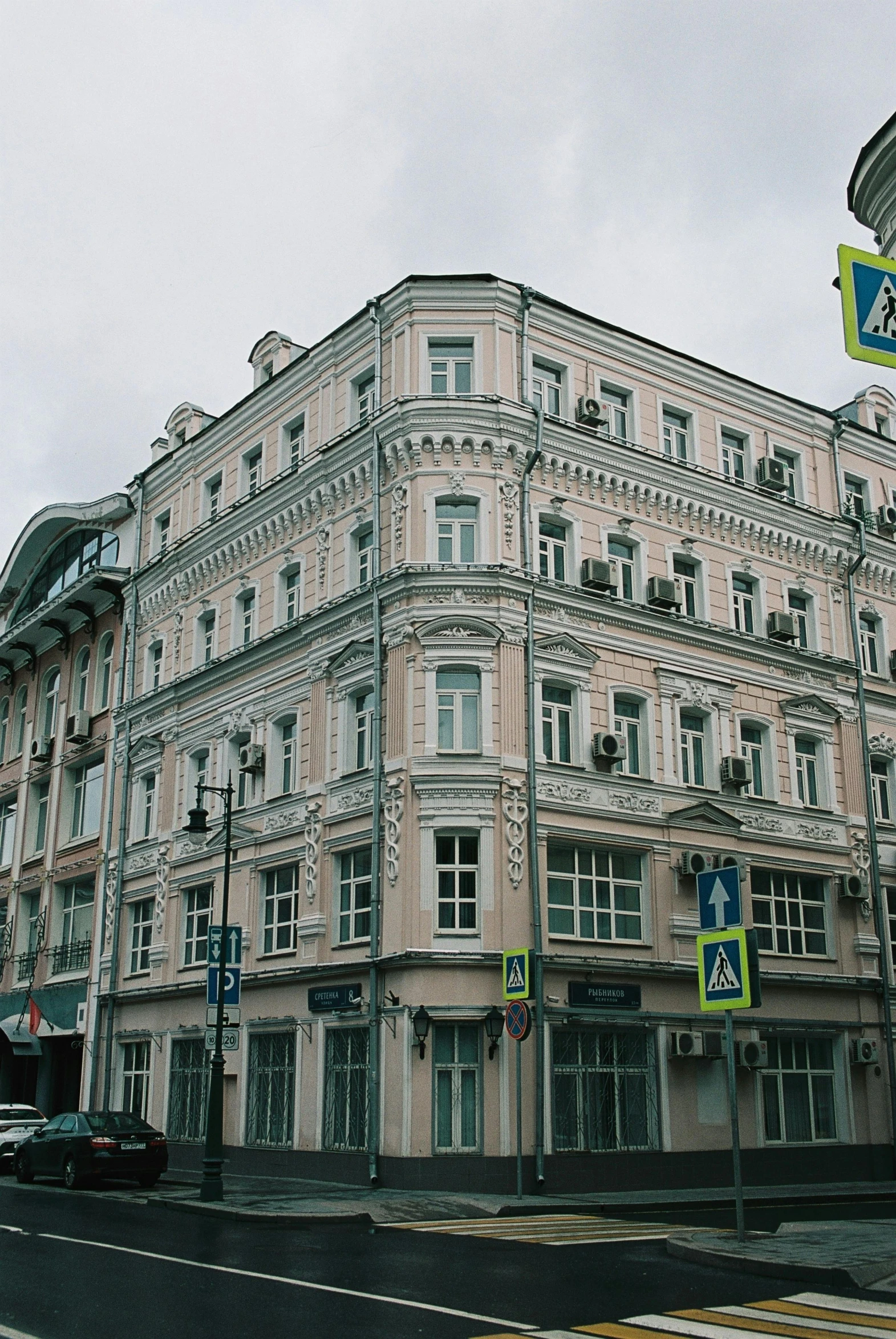 a large pink building sitting on the side of a road, inspired by Nikolai Alekseyevich Kasatkin, 000 — википедия, grey skies, old town, tiled