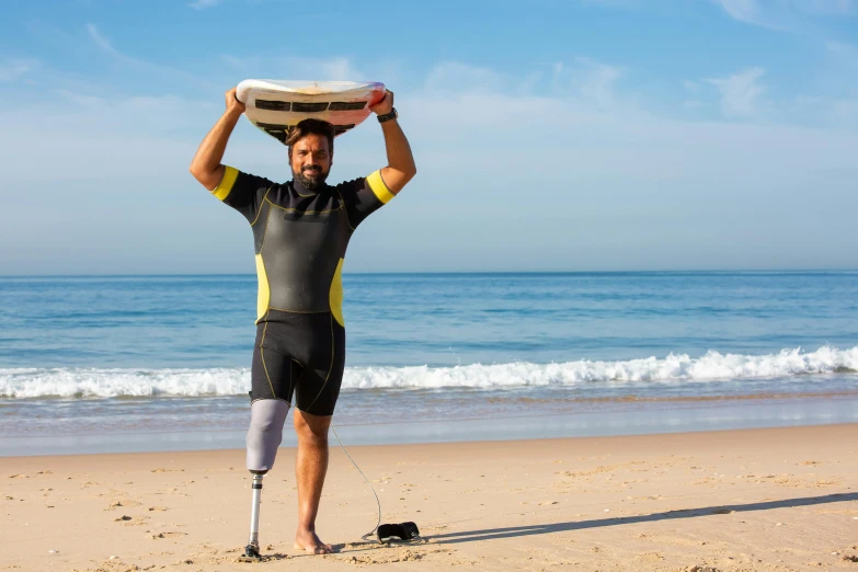 a man standing on a beach holding a surfboard on his head, prostheses, avatar image, injured, prosthetic leg