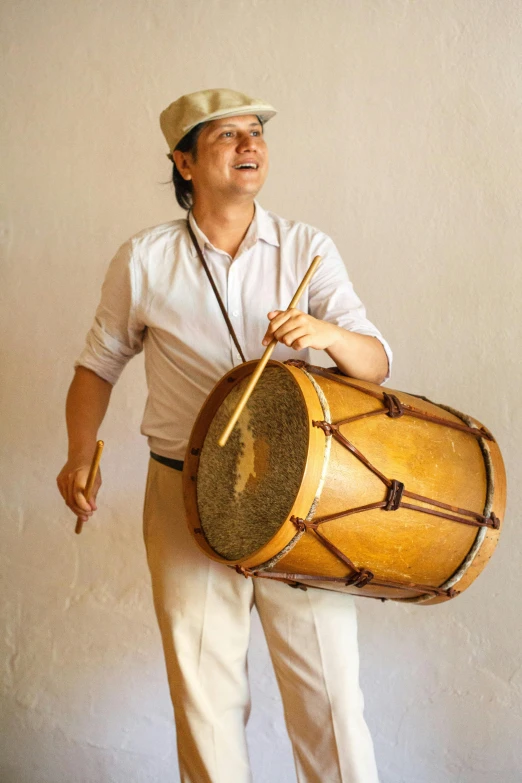 a man that is standing up with a drum, inspired by Cándido López, fully functional, brown