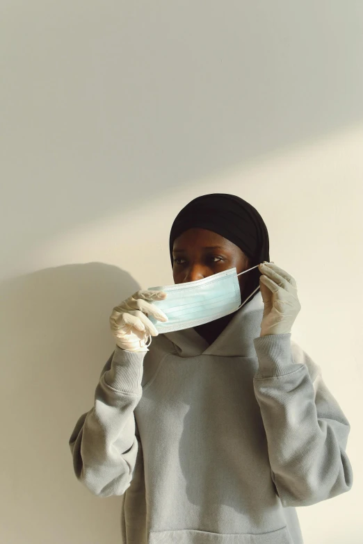 a woman with a face mask covering her mouth, by Lily Delissa Joseph, pexels contest winner, hyperrealism, somali woman, surgical mask covering mouth, virgil abloh, looking confident