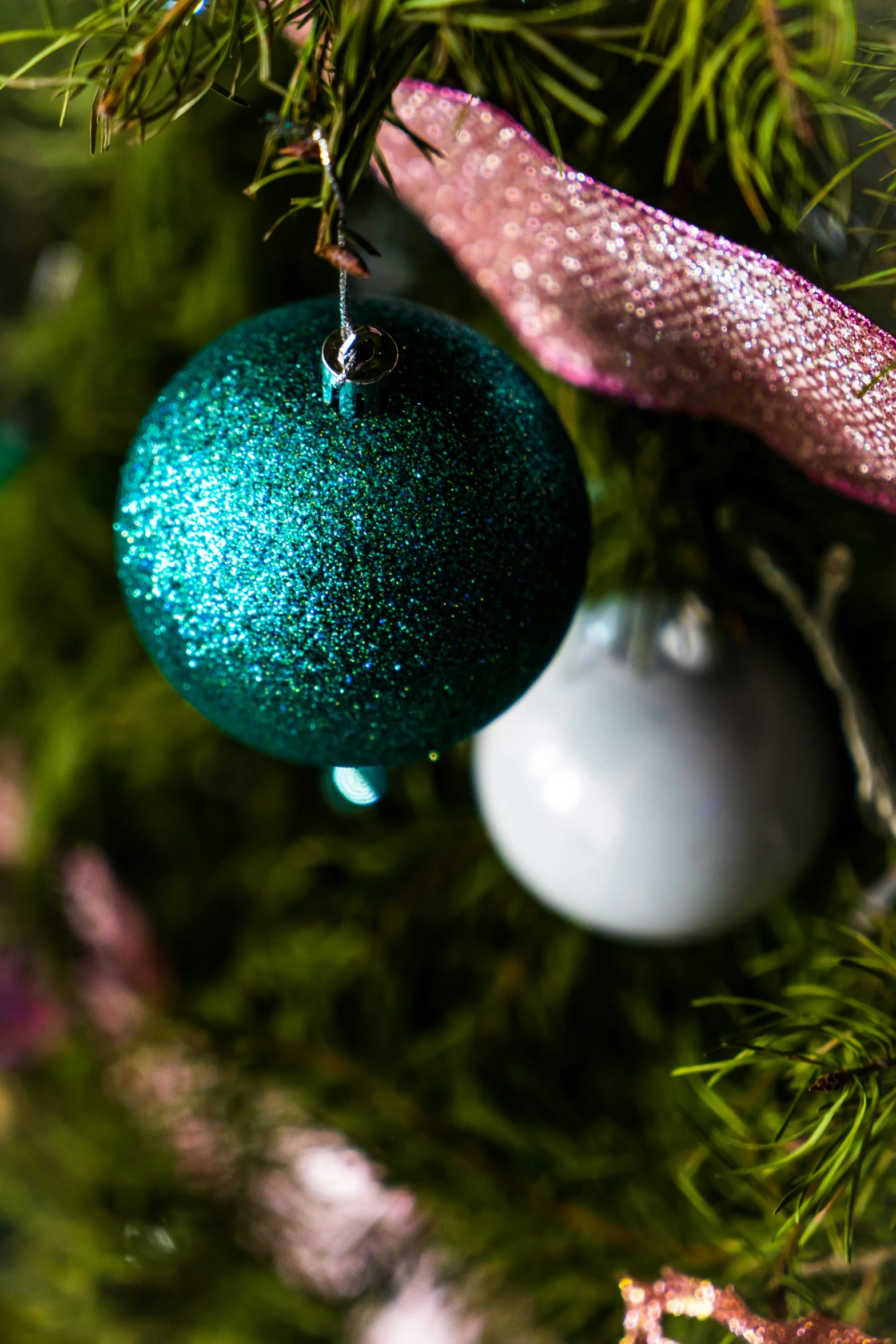 a close up of a christmas tree with ornaments, teal and pink, medium level shot, moss ball, uplit