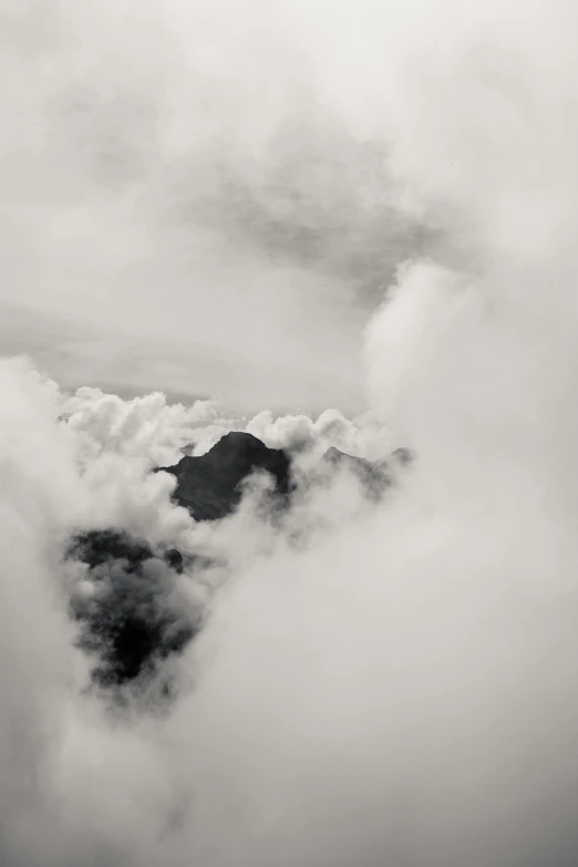 a black and white photo of clouds and mountains, a black and white photo, unsplash, surrealism, bird\'s eye view, volcanic, cloud jumper, made of mist