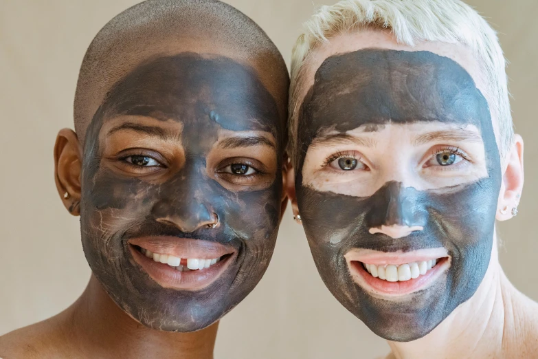 a couple of people with facial masks on their faces, trending on pexels, antipodeans, rotting black clay skin, clear [bronze] face, genderless, large black smile