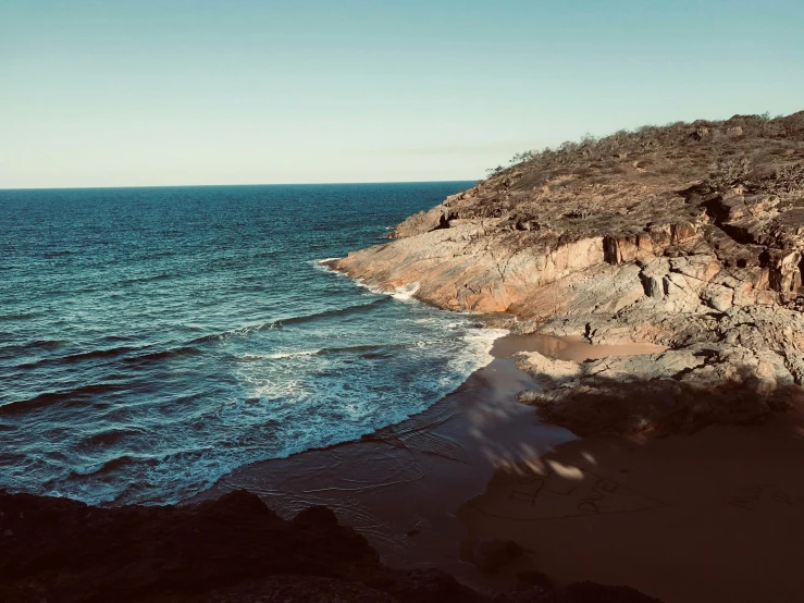 a large body of water next to a rocky shore, a photo, unsplash, australian tonalism, sunfaded, instagram picture, beaches, high cliff