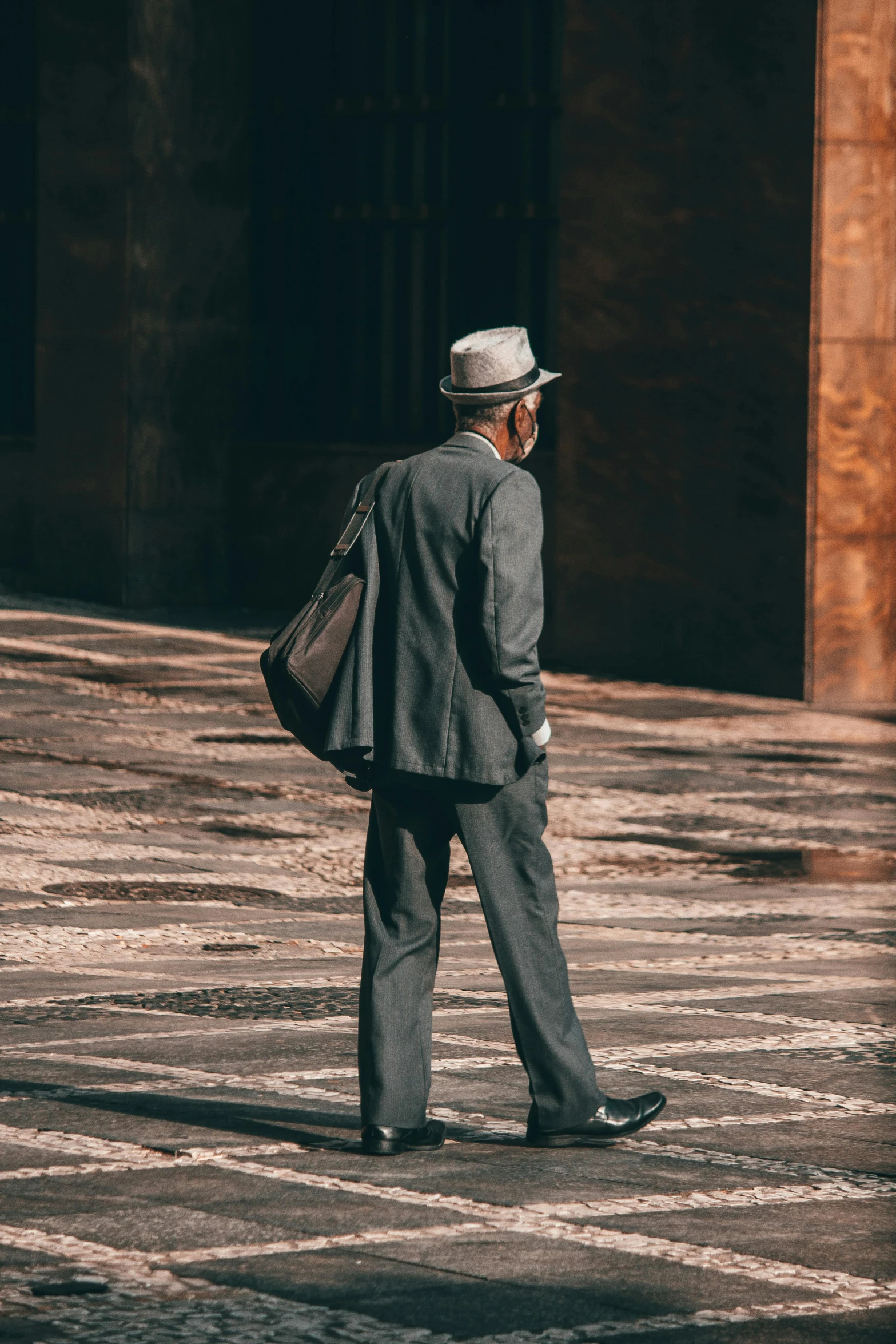 a man in a suit and hat walking down a street, pexels contest winner, modernism, professor clothes, back turned, aged, in barcelona