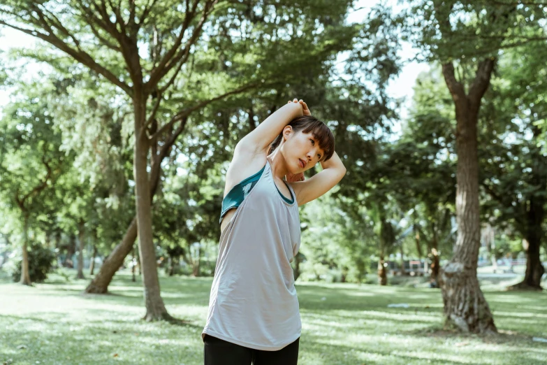 a woman stretching her arms in a park, pexels contest winner, hurufiyya, wearing : tanktop, cai xukun, thumbnail, down left arm and back