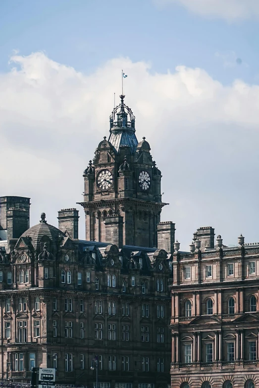 a large building with a clock on top of it, in scotland, city views, turrets, zoomed out