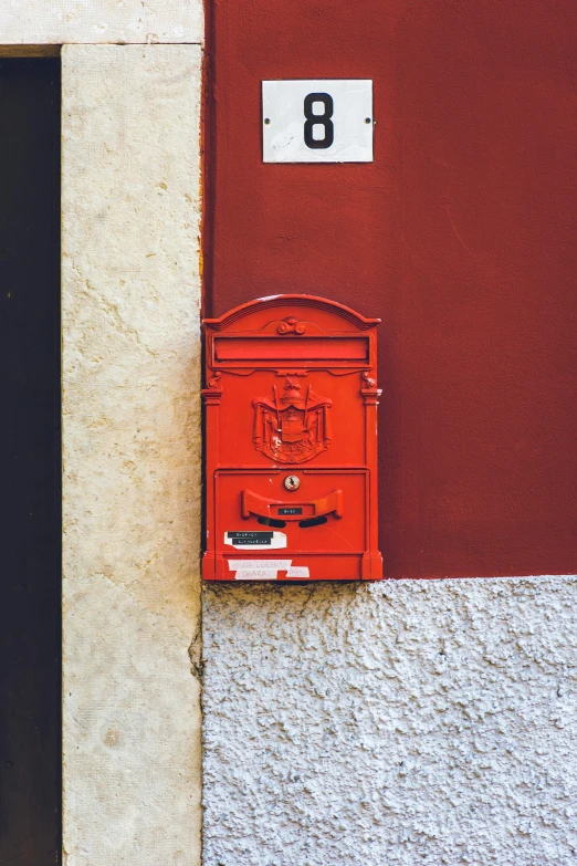 a red mail box sitting on the side of a building, an album cover, pexels contest winner, italy, ornate, orange, exterior