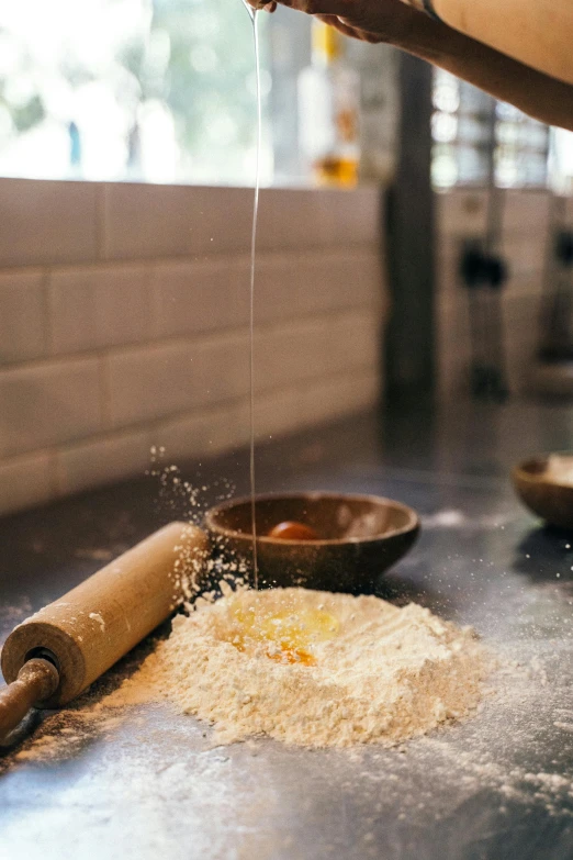 a woman sprinkles flour onto a rolling pin, unsplash, chef table, square, amber, from street level