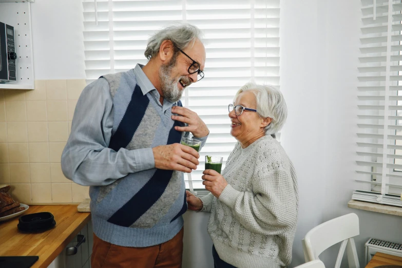 a man and woman standing next to each other in a kitchen, pexels contest winner, old lady screaming and laughing, holding a drink, greens), on a white table