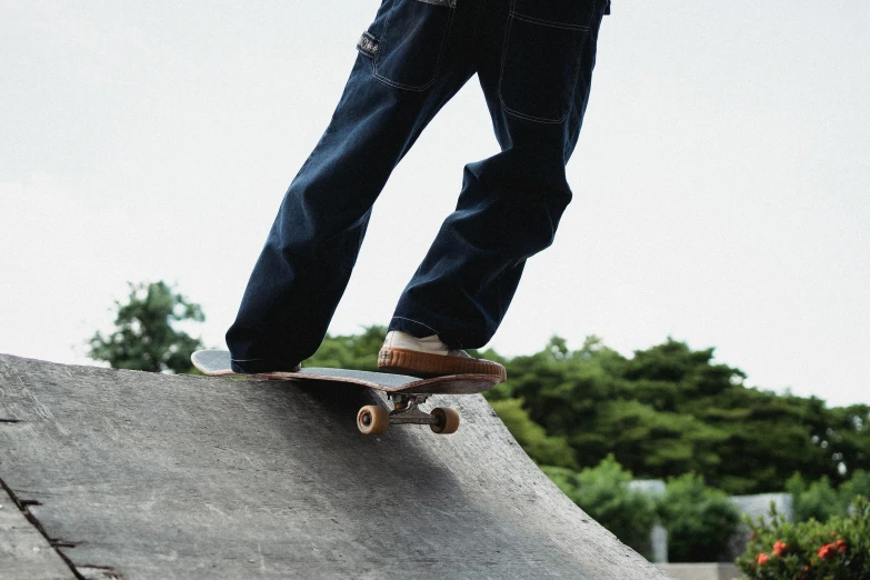 a man riding a skateboard up the side of a ramp, trending on pexels, ( ( ( wearing jeans ) ) ), japanese collection product, carving, at a park