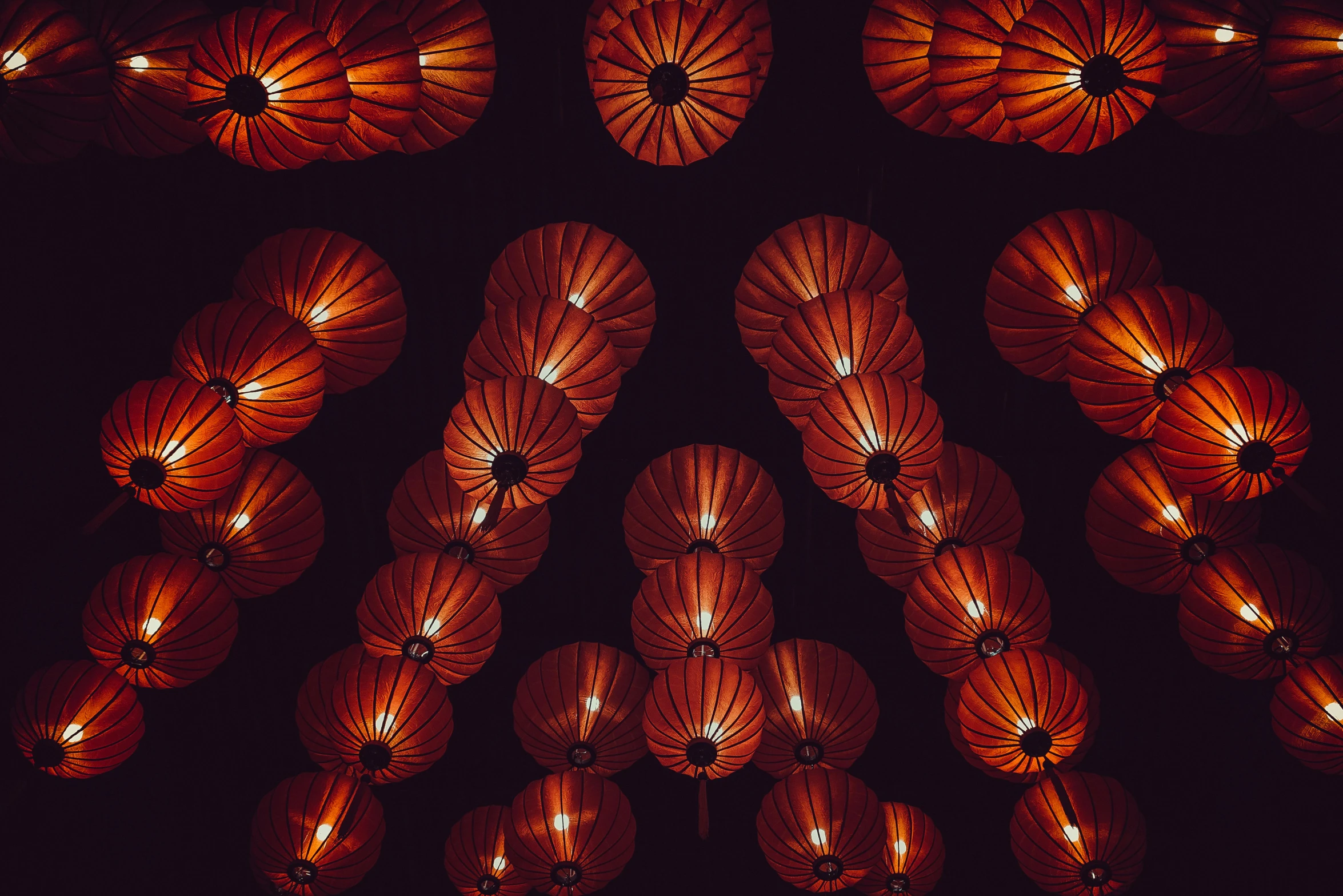 a bunch of red paper lanterns hanging from the ceiling, an album cover, inspired by Ai Weiwei, pexels contest winner, black and orange colour palette, night photo, vietnam, brown