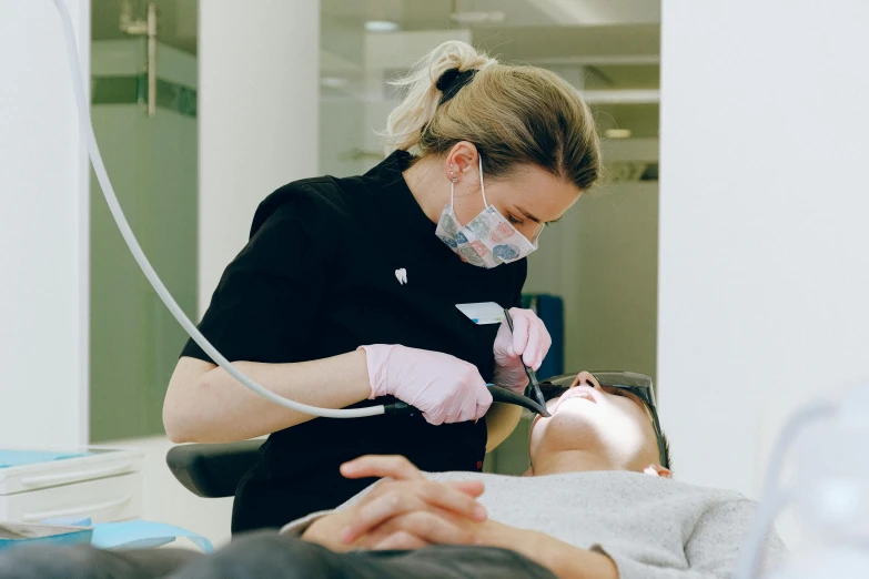 a woman getting her teeth examined by a dentist, by Emma Andijewska, pexels contest winner, square masculine jaw, burned, extra crisp image, profile image