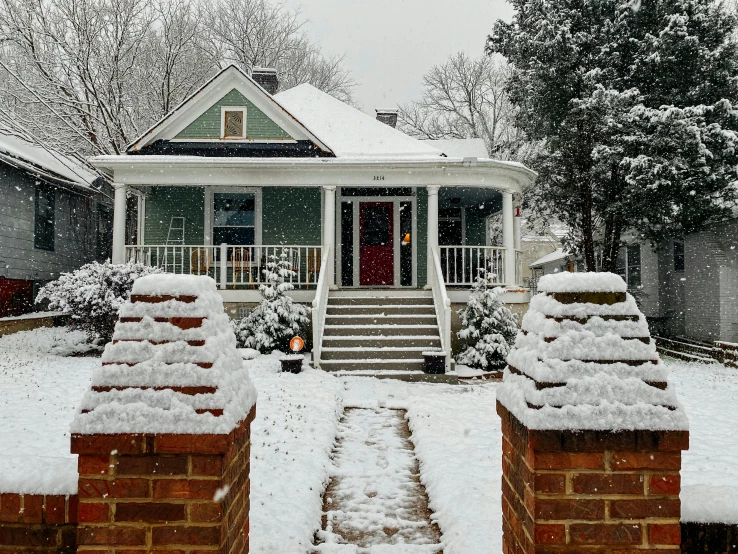 a house is covered in snow on a snowy day, by Carey Morris, pexels contest winner, fan favorite, 1910s architecture, front, a green