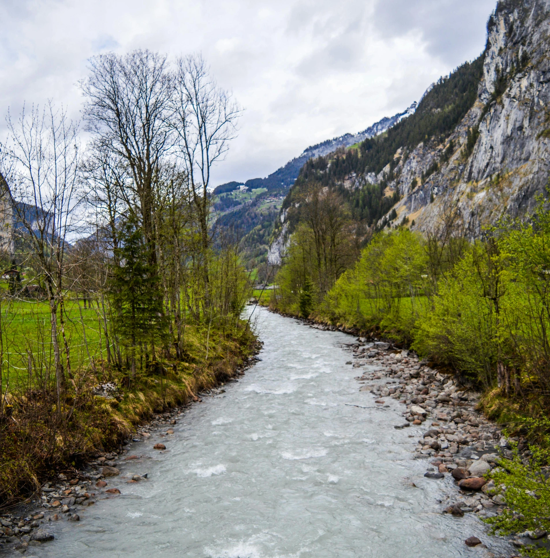a river running through a lush green valley, inspired by Karl Stauffer-Bern, pexels contest winner, hurufiyya, grey, festivals, 4k image”