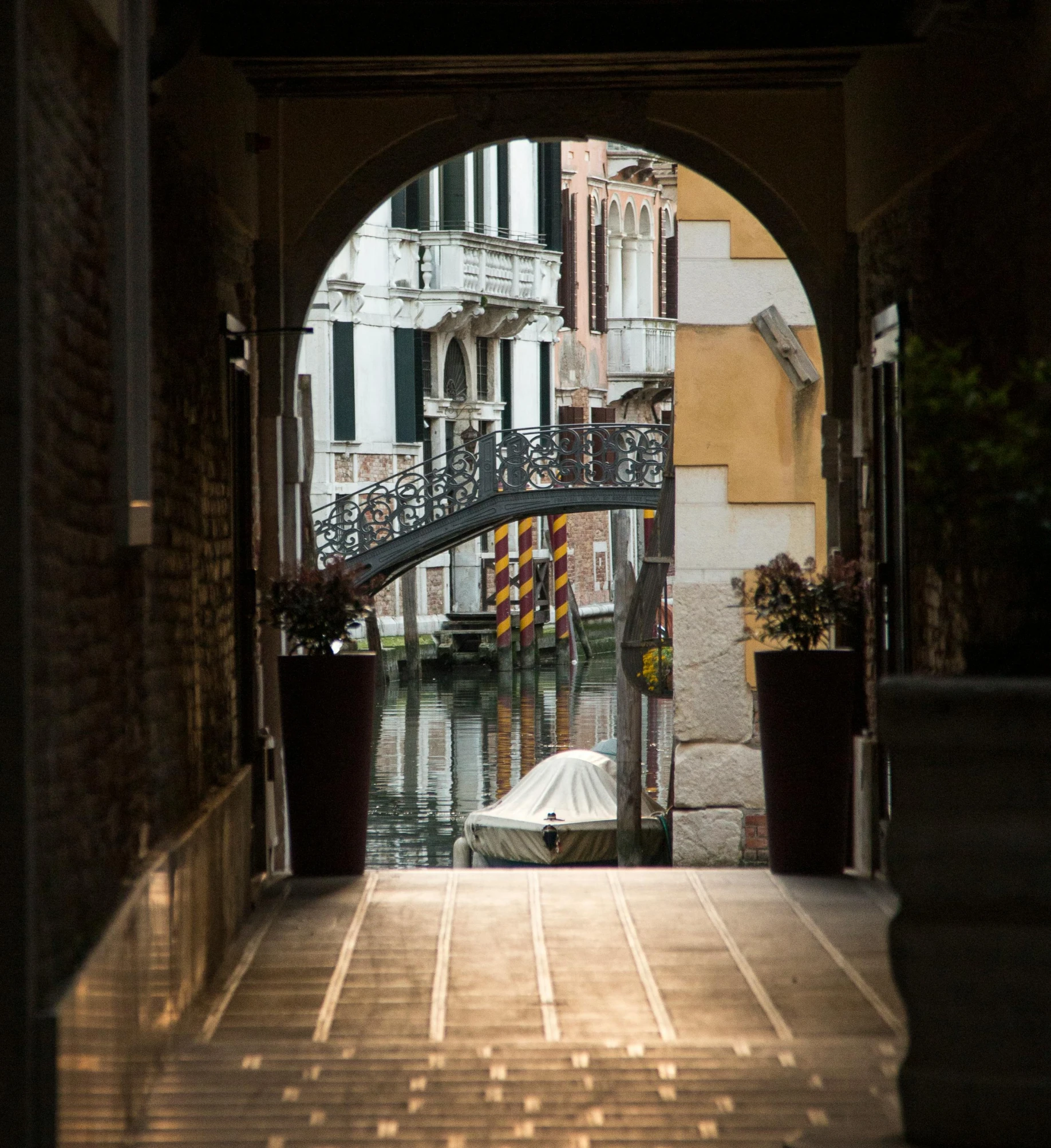 a view of a canal through an archway, pexels contest winner, venice biennale's golden lion, morning hard light, brown