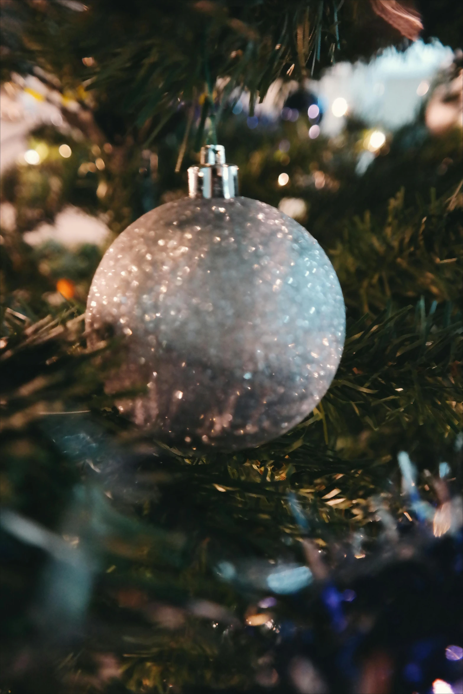 a close up of a christmas ornament on a tree, pexels, grey and silver, thumbnail, softly lit, full colour