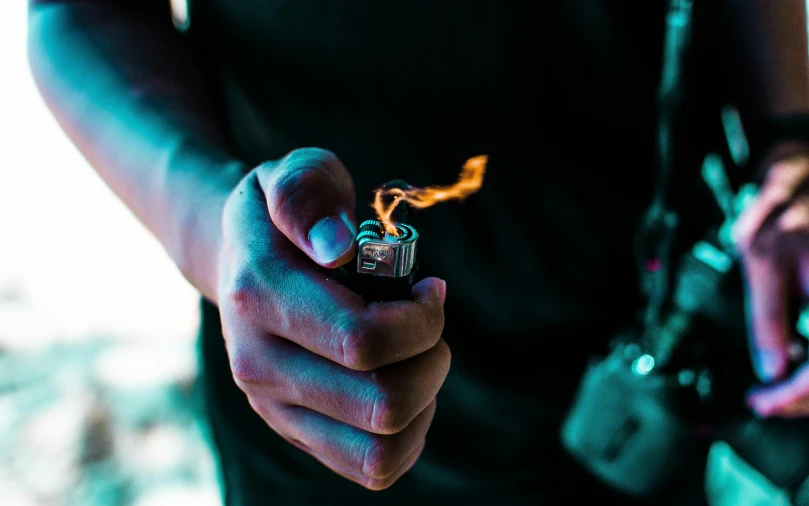 a person holding a lighter in their hand, pexels contest winner, instagram post, high intensity, shot with sigma f/ 4.2, mid riff