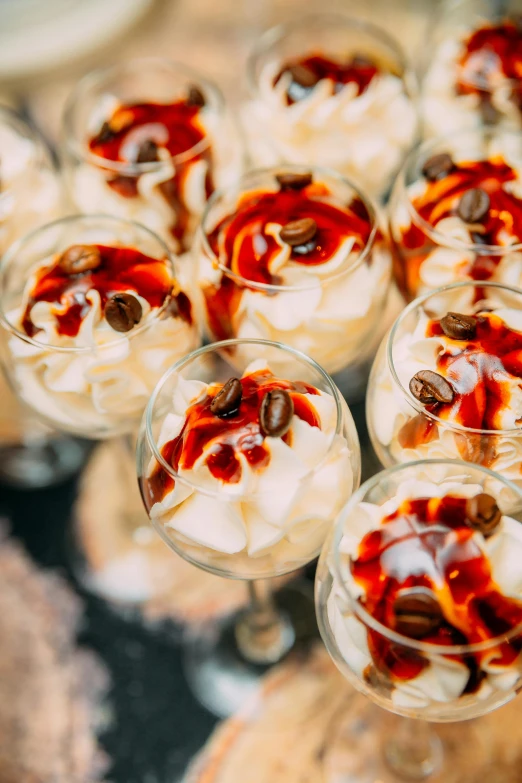 a group of desserts sitting on top of a wooden table, inspired by Elsa Bleda, unsplash, baroque, ice coffee, an island made of red caviar, white russian clothes, closeup - view