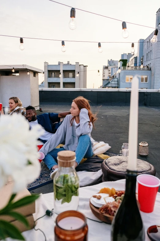 a group of people sitting on top of a roof, trending on unsplash, people are eating, rooftop romantic, square, teenage girl