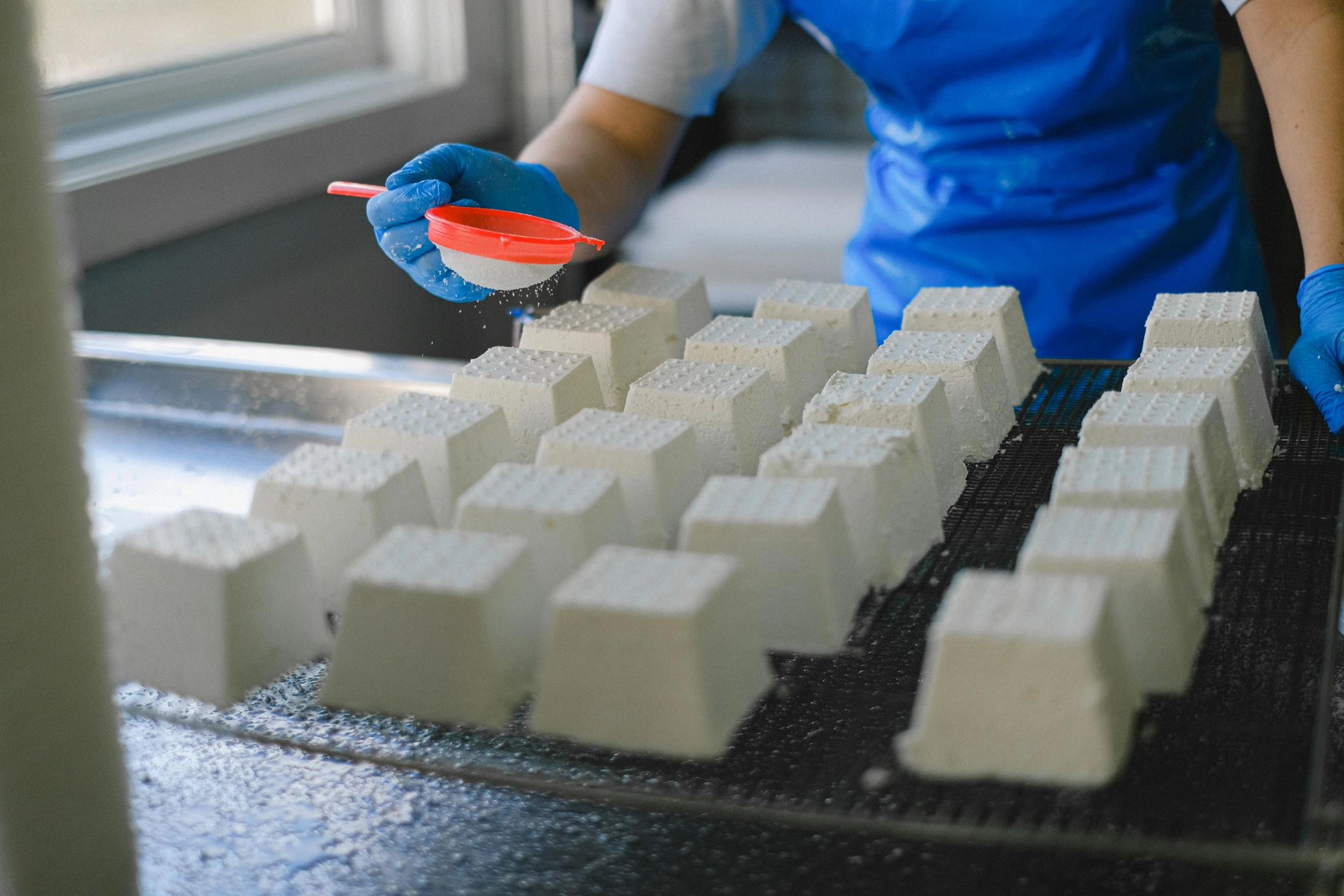 a person wearing blue gloves and a blue apron, a marble sculpture, unsplash, process art, milk cubes, many cryogenic pods, melbourne, thousands of teeth