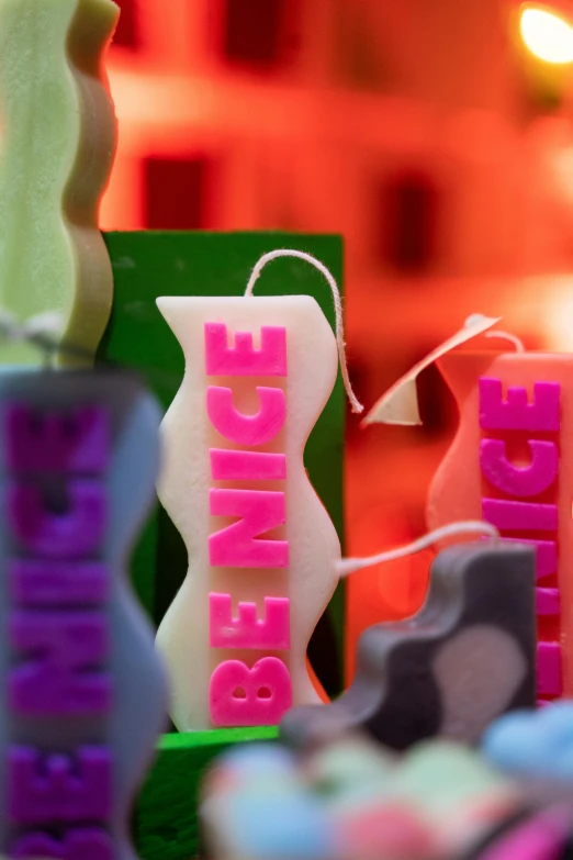 a group of candles sitting on top of a table, colorful signs, upclose, sculpted out of candy, profile image