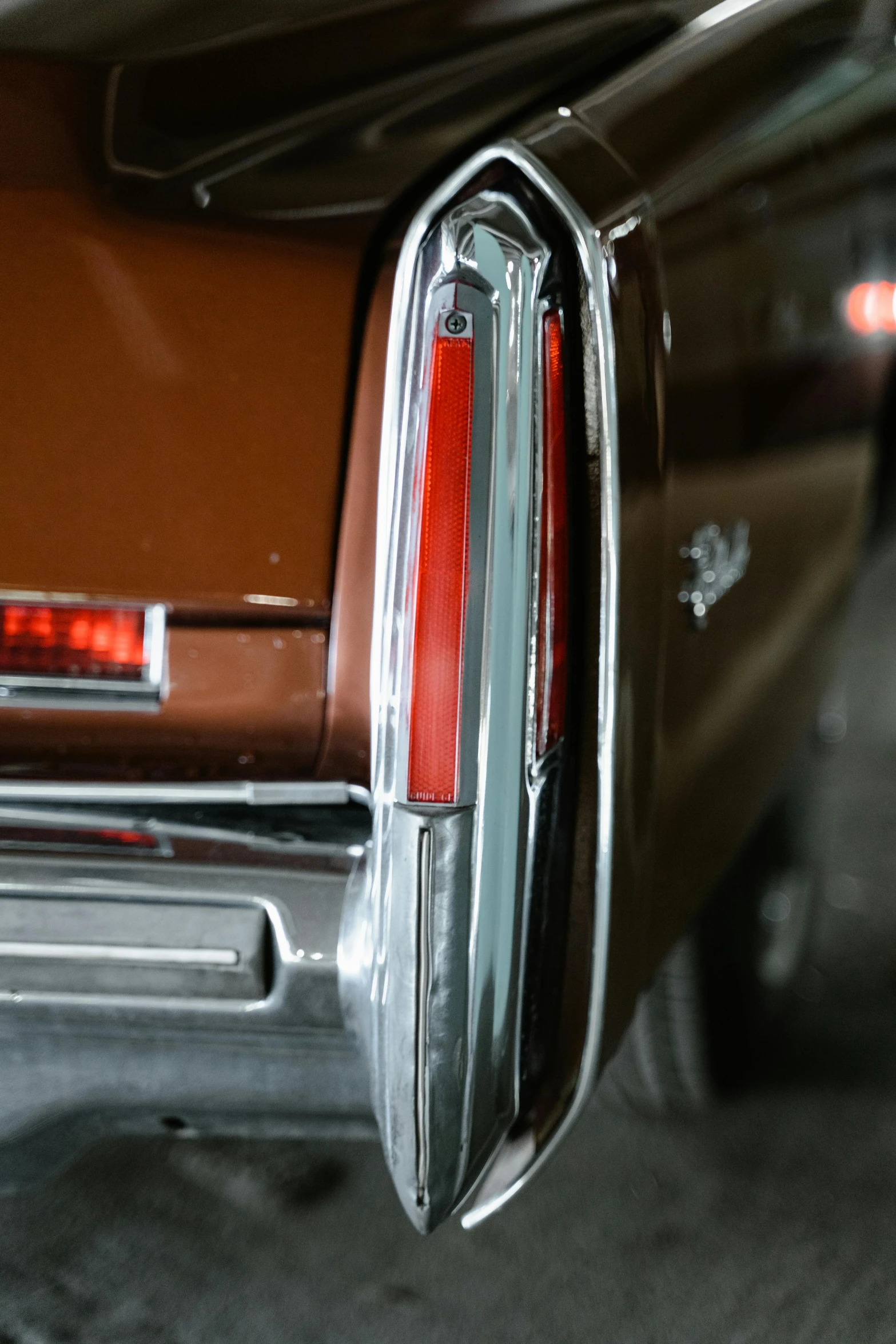 a close up of the tail lights of a car, an album cover, by Dave Melvin, pexels contest winner, photorealism, brown, chrome plated, side lighting xf iq4, 1970's