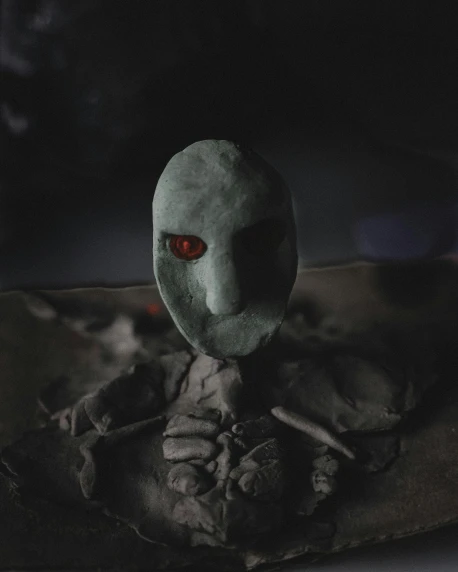 a close up of a statue of a person with red eyes, inspired by Roger Ballen, pexels contest winner, concrete art, volcanic skeleton, made of glowing wax and ceramic, alternate album cover, clay render