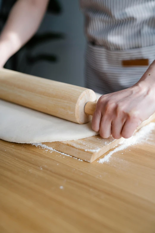 a person rolling out dough on a wooden table, inspired by Maki Haku, trending on pexels, vine twist, large portrait, vanilla, straight neck