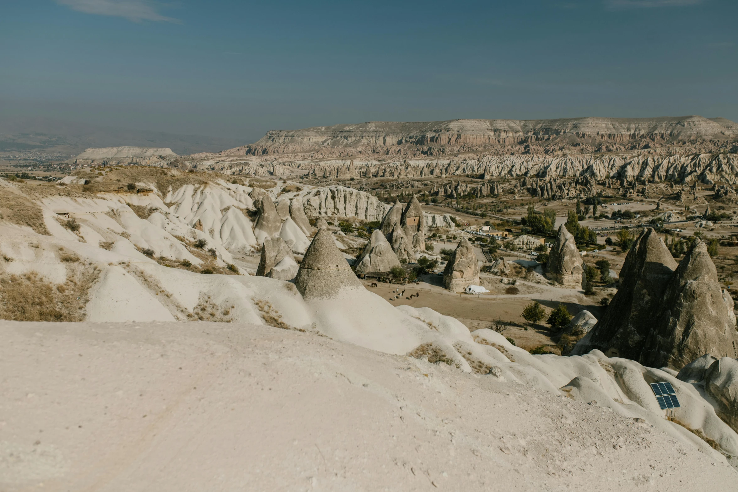 a man standing on top of a mountain next to a valley, a marble sculpture, pexels contest winner, art nouveau, black domes and spires, turkey, sand, group of seven