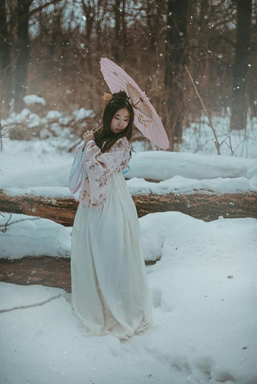 a woman standing in the snow holding a pink umbrella, inspired by Itō Shinsui, pexels contest winner, wearing a white flowing dress, vietnamese woman, full body:: snow outside::, victorian inspired clothing