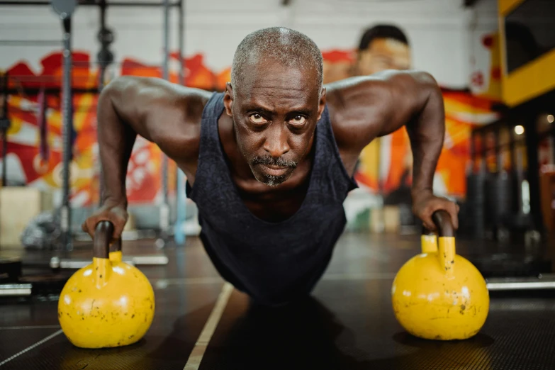 a man doing push ups with kettlebells in a gym, by Sam Charles, pexels contest winner, portrait of hide the pain harold, man is with black skin, determined expression, 2 0 2 2 photo