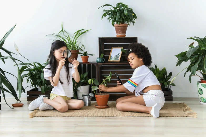 two girls sitting on the floor playing with plants, pexels contest winner, avatar image, future activist, magnifying glass, natural mini gardens