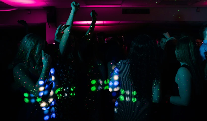 a group of people dancing at a party, a hologram, pexels, fuschia leds, bedazzled, back lighting, boke