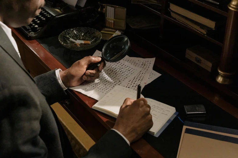 a man sitting at a desk looking through a magnifying glass, pexels contest winner, private press, still from loki ( 2 0 2 1 ), character sheets on table, mystery and detective themed, back of hand on the table