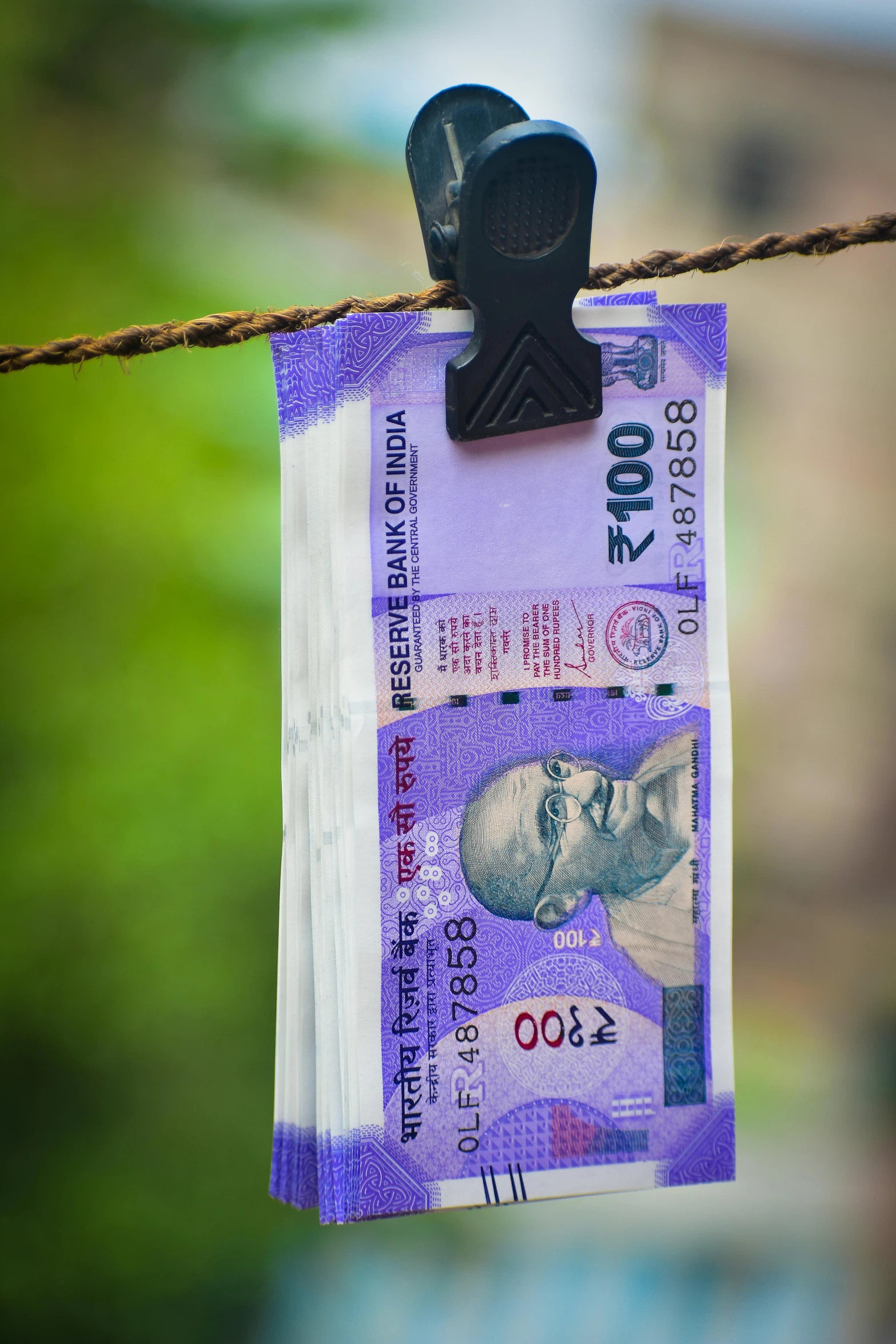 a bunch of indian currency hanging on a rope, a portrait, by Daniel Lieske, pexels contest winner, “hyper realistic, backlit, promo image, theft