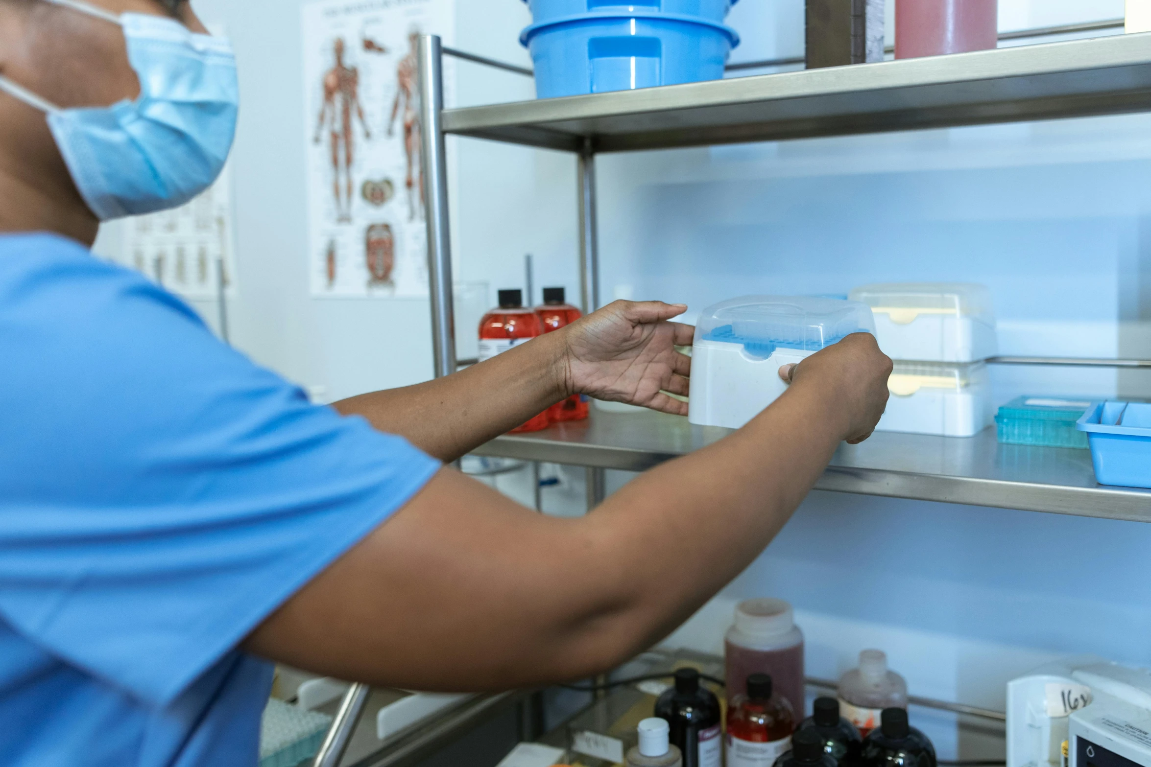 a person in a blue shirt and a face mask, blood collection vials, surgical impliments, thumbnail, full body image