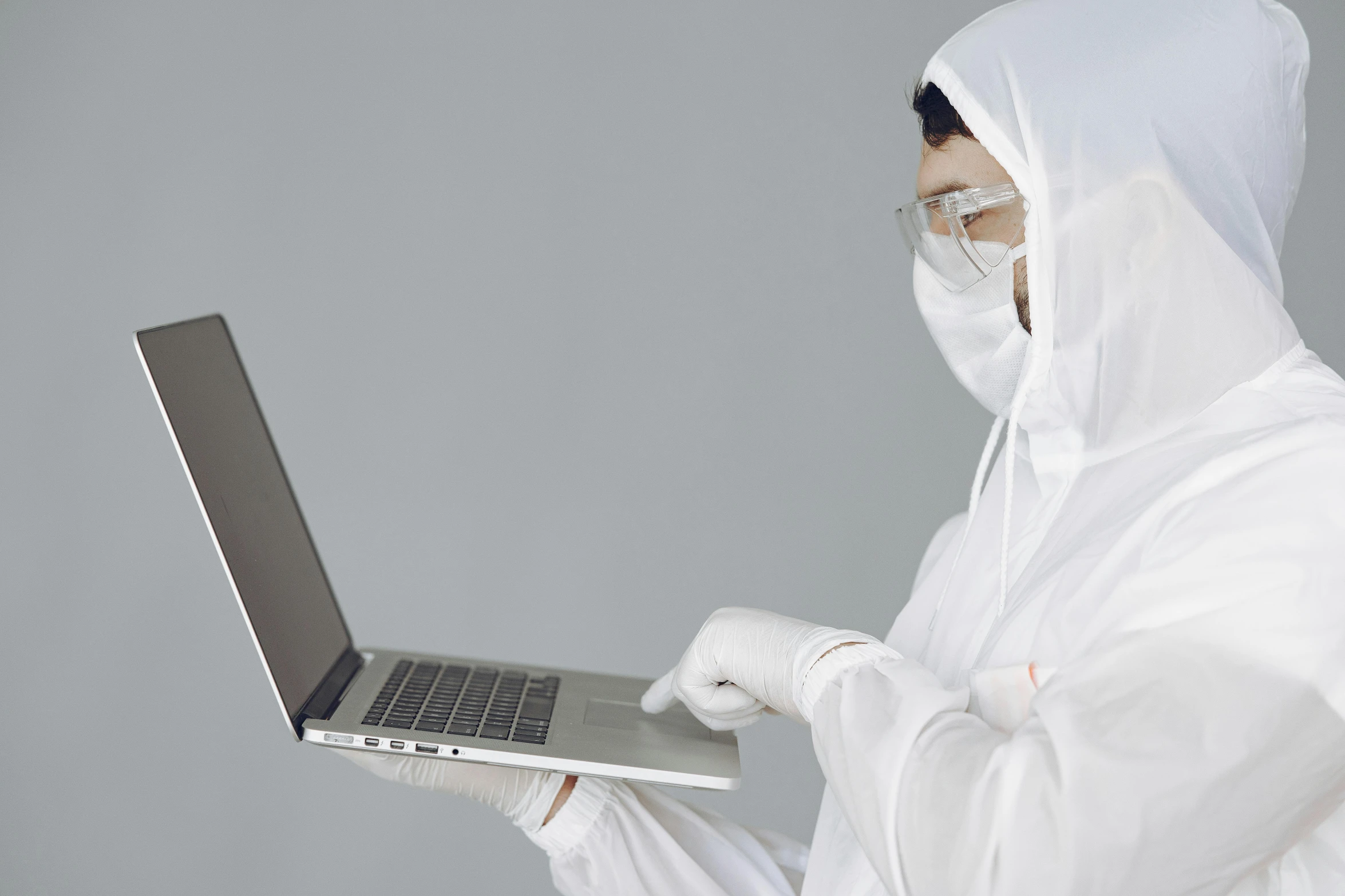 a man in a white lab coat holding a laptop, an album cover, inspired by Bernardino Mei, unsplash, face covered, tech robes, cybersuits, clean medical environment