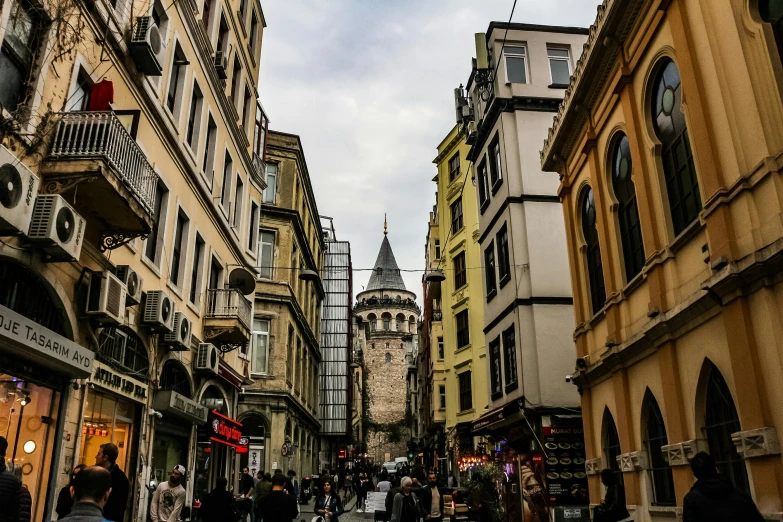 a group of people walking down a street next to tall buildings, a photo, pexels contest winner, art nouveau, ottoman sultan, thumbnail, castle towers, riyahd cassiem