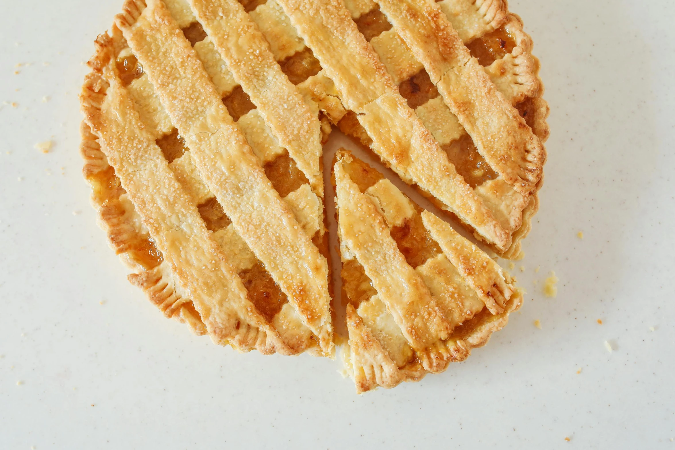 a close up of a pie on a table, on a pale background, one on each side, cut out, lattice