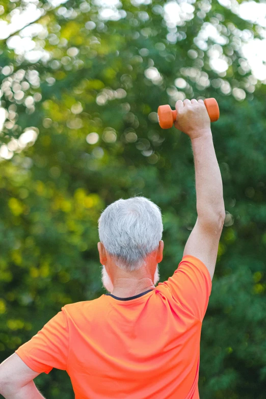 a man in an orange shirt lifting a pair of dumbbells, by Dan Content, happening, an elderly, outdoors, profile image, raising an arm