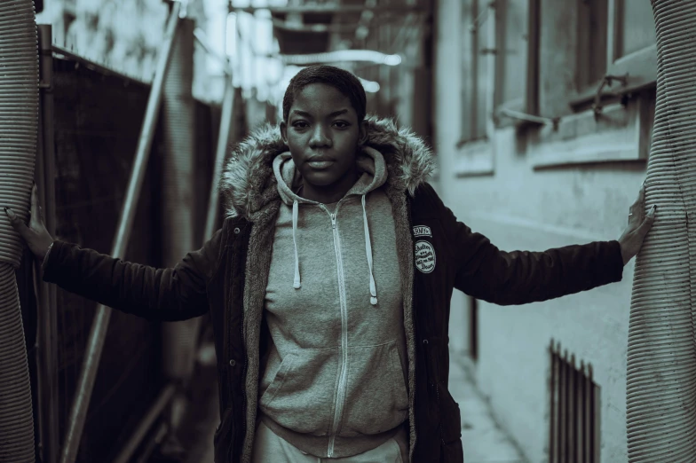 a black and white photo of a woman talking on a cell phone, an album cover, by Alasdair Grant Taylor, unsplash, graffiti, wearing a hoody, black young woman, shrugging, **cinematic