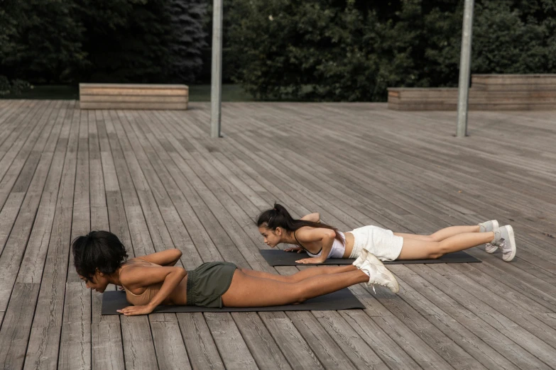 two women doing push ups on a wooden deck, by Emma Andijewska, happening, tans, 5k, high-quality photo, 6 pack