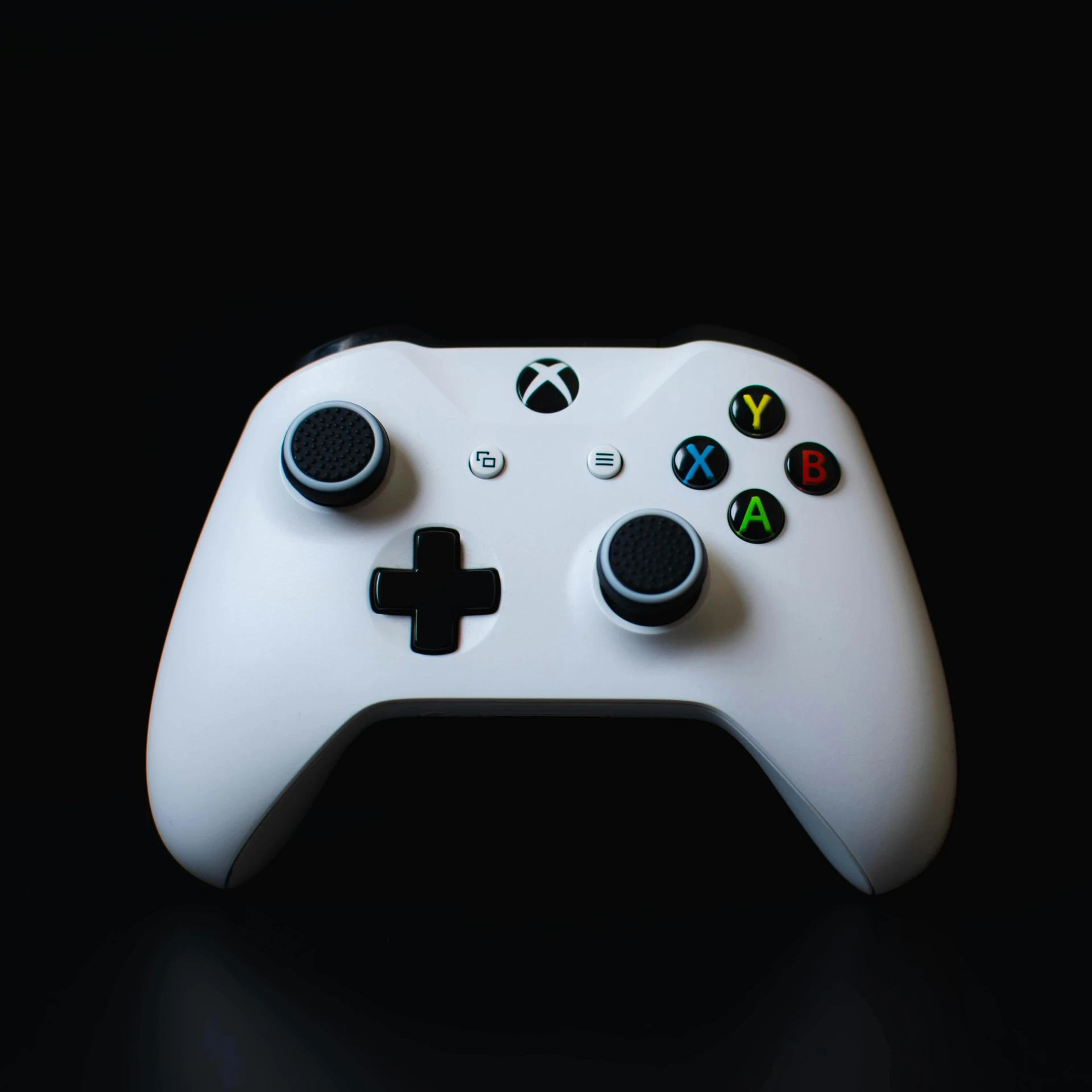 a white xbox controller sitting on top of a table, by Niels Lergaard, pexels, in front of a black background, set against a white background, educational, ultra realistic classic