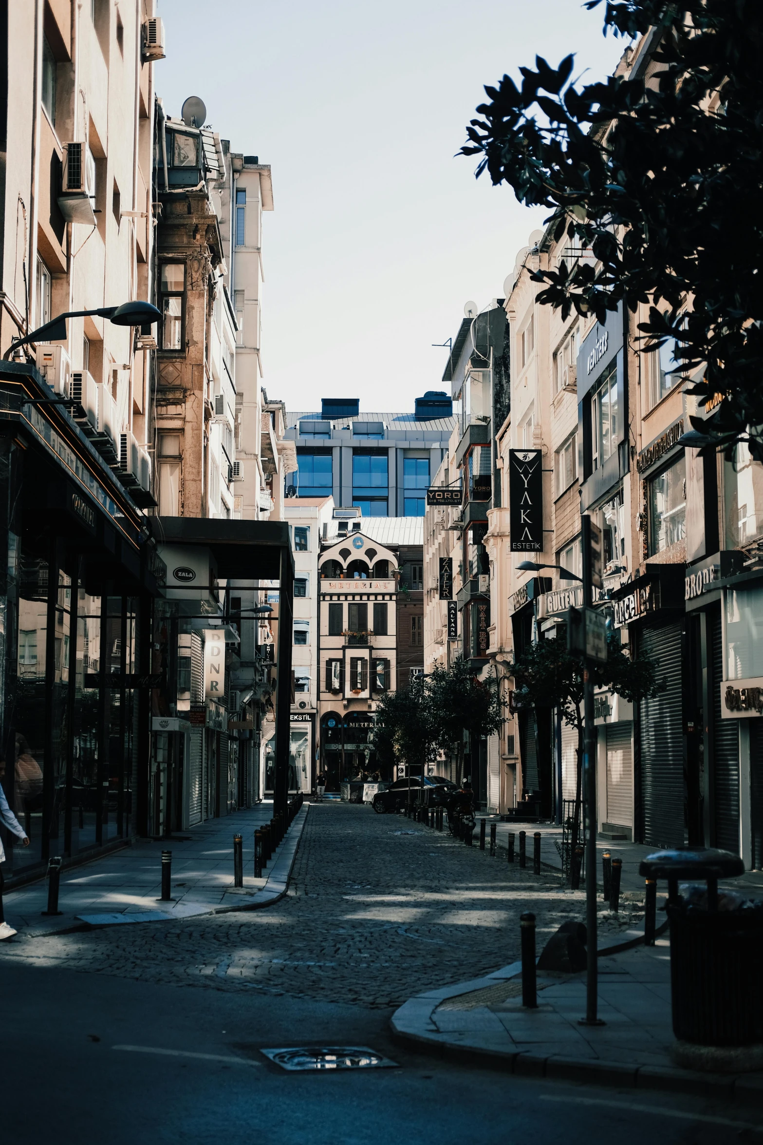 a man riding a skateboard down a street next to tall buildings, a picture, by Niyazi Selimoglu, pexels contest winner, renaissance, gothic city streets behind her, istanbul, gif, in savannah