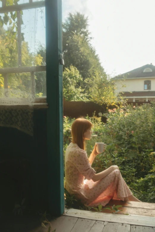 a woman sitting on a porch looking out a window, a picture, inspired by William Stott, unsplash, in a garden of a house, morning coffee, petra collins, medium format. soft light